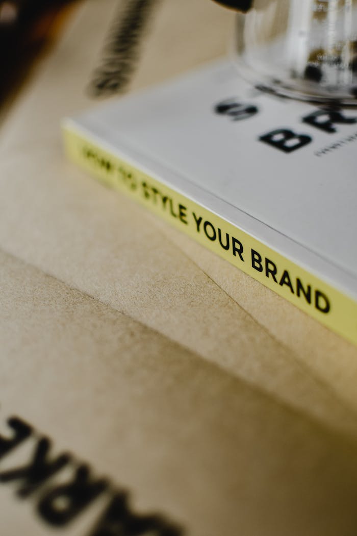 Features A close-up of a book titled "How to Style Your Brand" on a paper background.