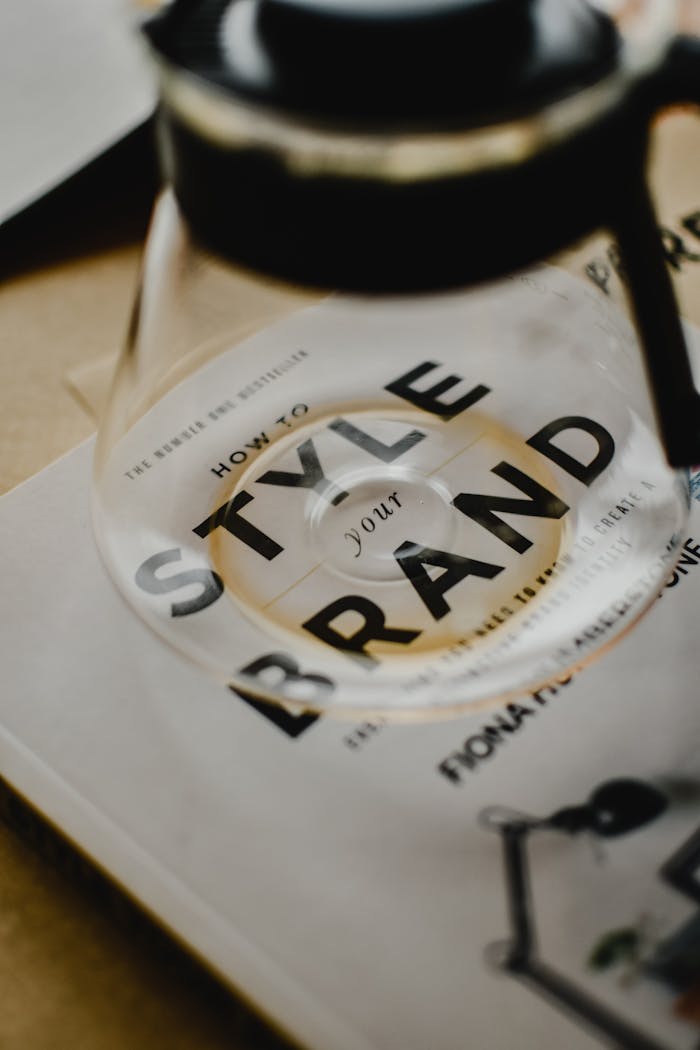 Features A coffee pot rests atop a book titled 'How to Style Your Brand', capturing the essence of creative branding.